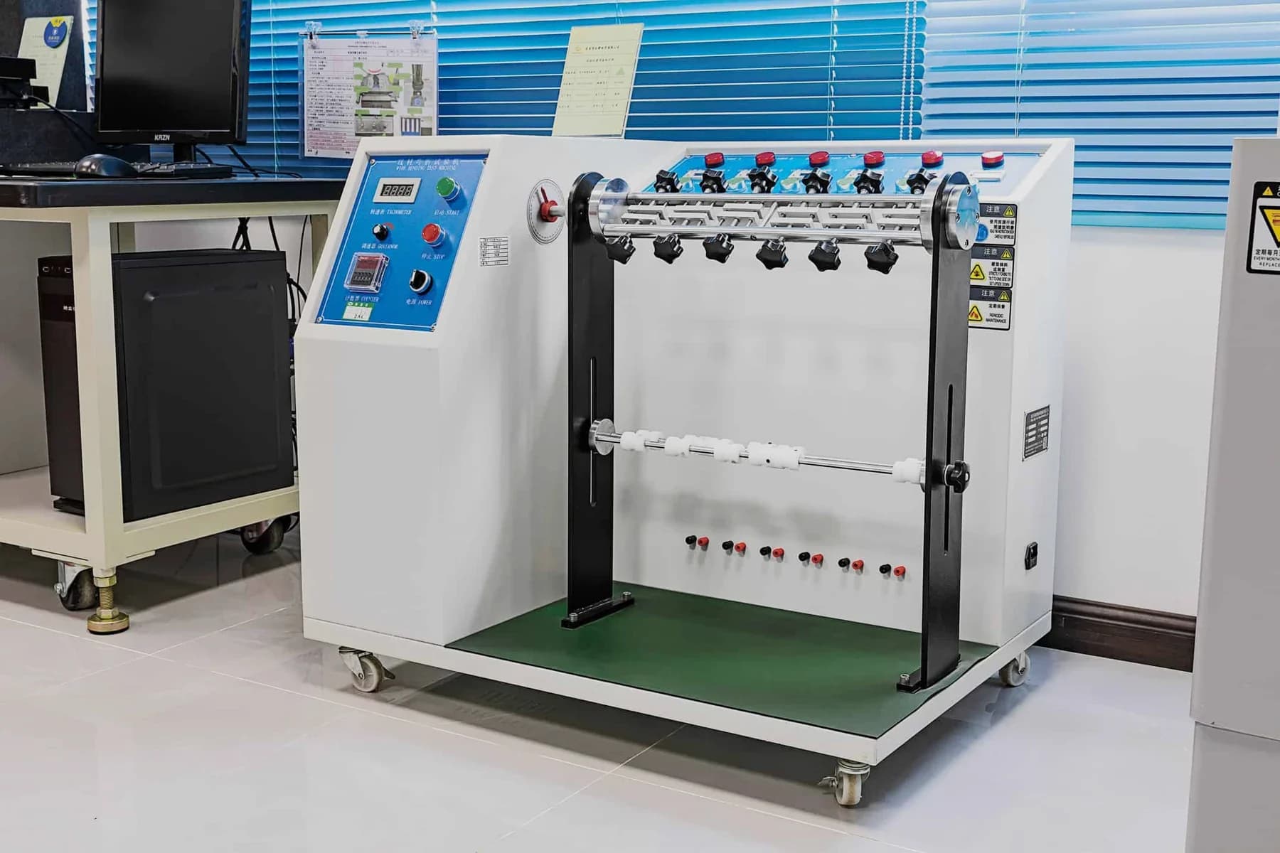 Bend test rig with a row of clamped cables and a control desk in the test laboratory
