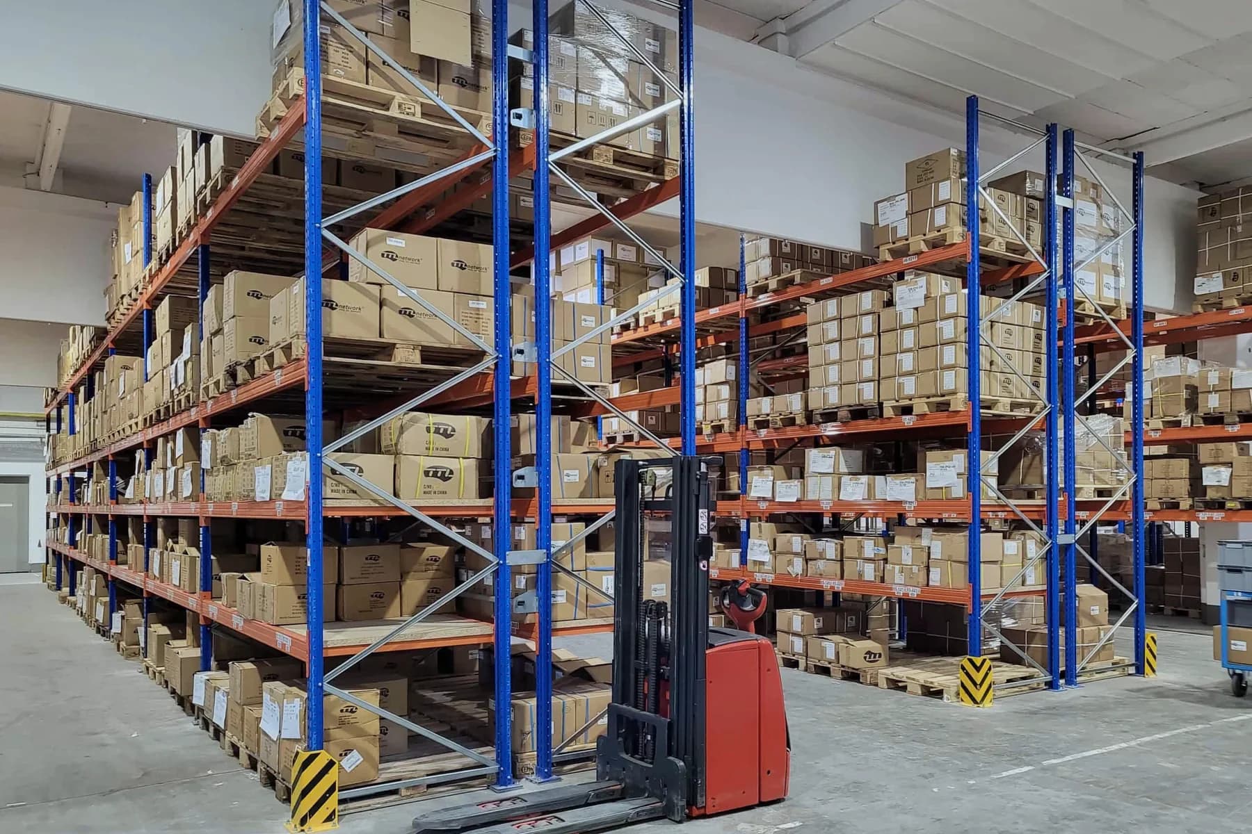 TTL Network high-bay warehouse in Halle (Westfalen) with palletised goods and a pallet truck in front