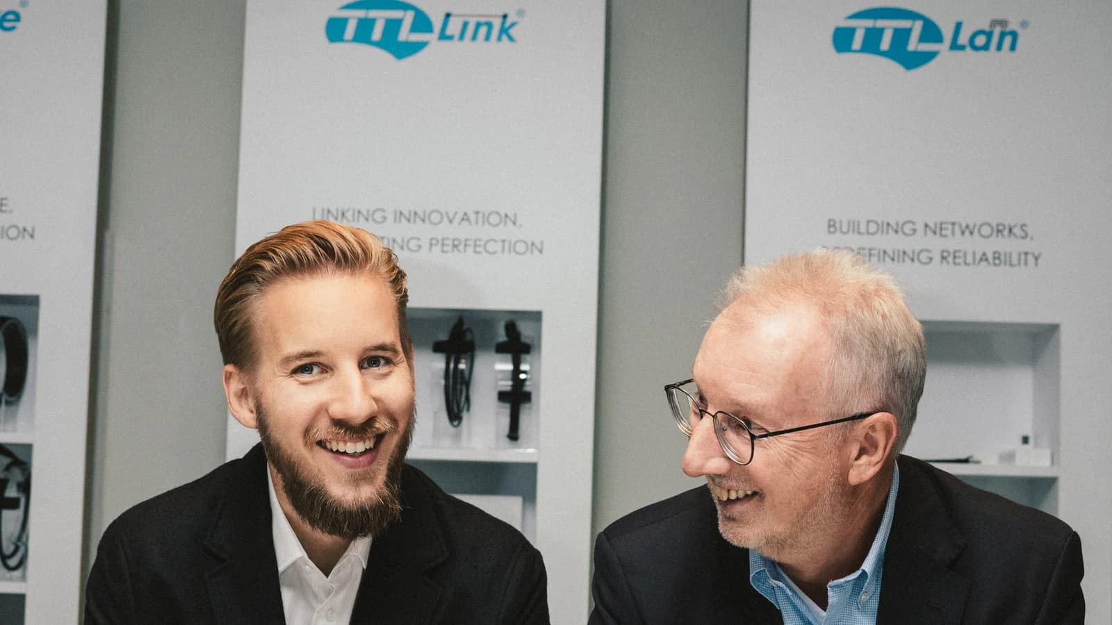 Achim and Tobias Beuckes in conversation in front of the TTL Network brand displays